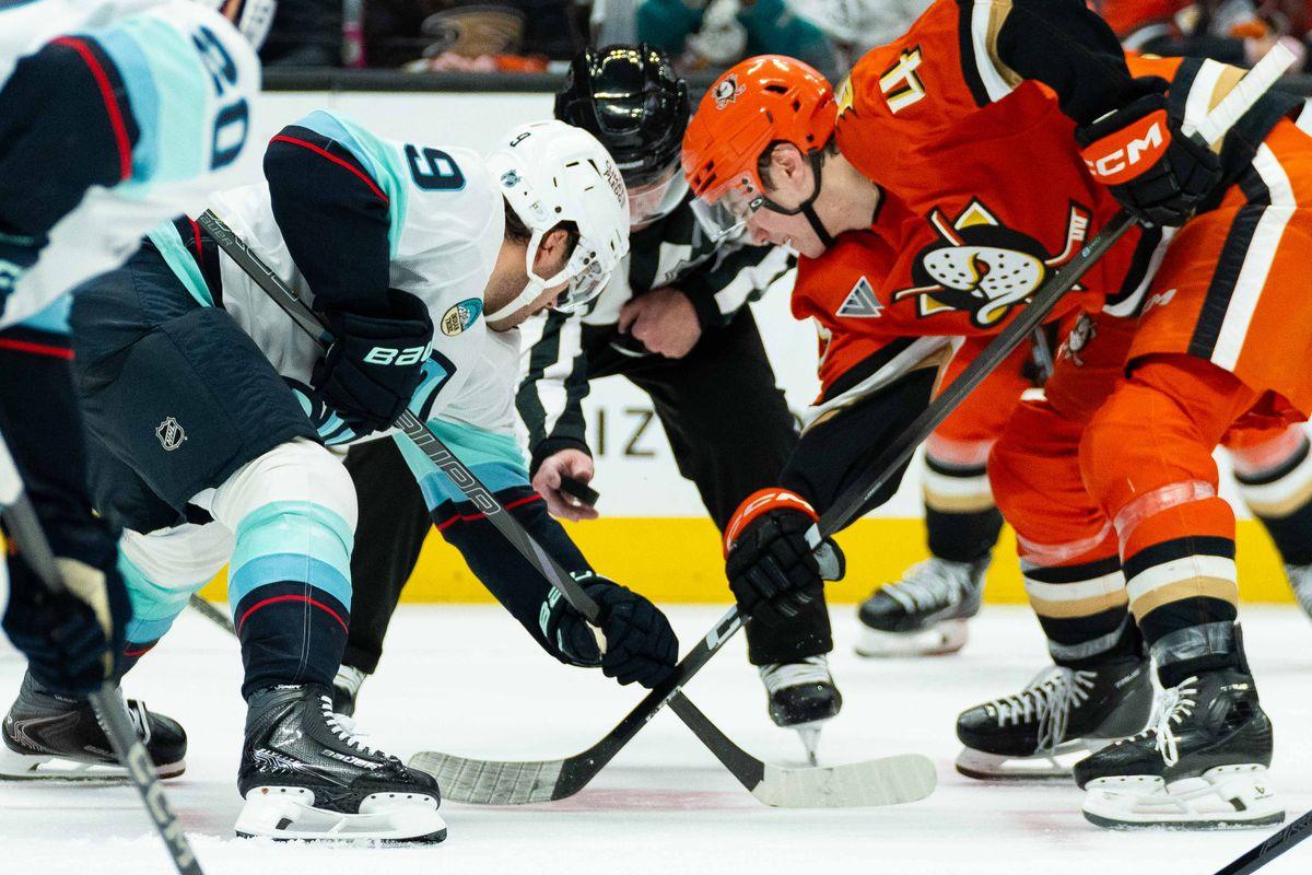 Kraken and Ducks players taking a faceoff