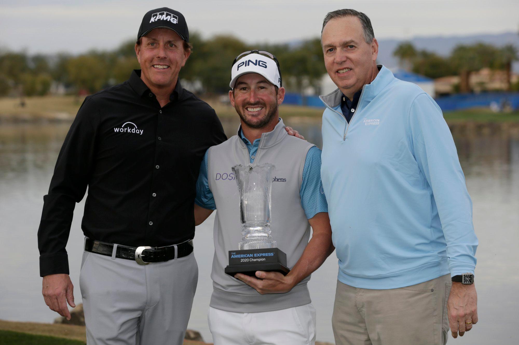 Andrew Landry, center, holds the trophy with Phil Mickelson, left, and CEO of American Express Steve Squeri after winning The American Express golf tournament on the Stadium Course at PGA West in La Quinta, Calif., Sunday, Jan. 19, 2020. (AP Photo/Alex Gallardo)