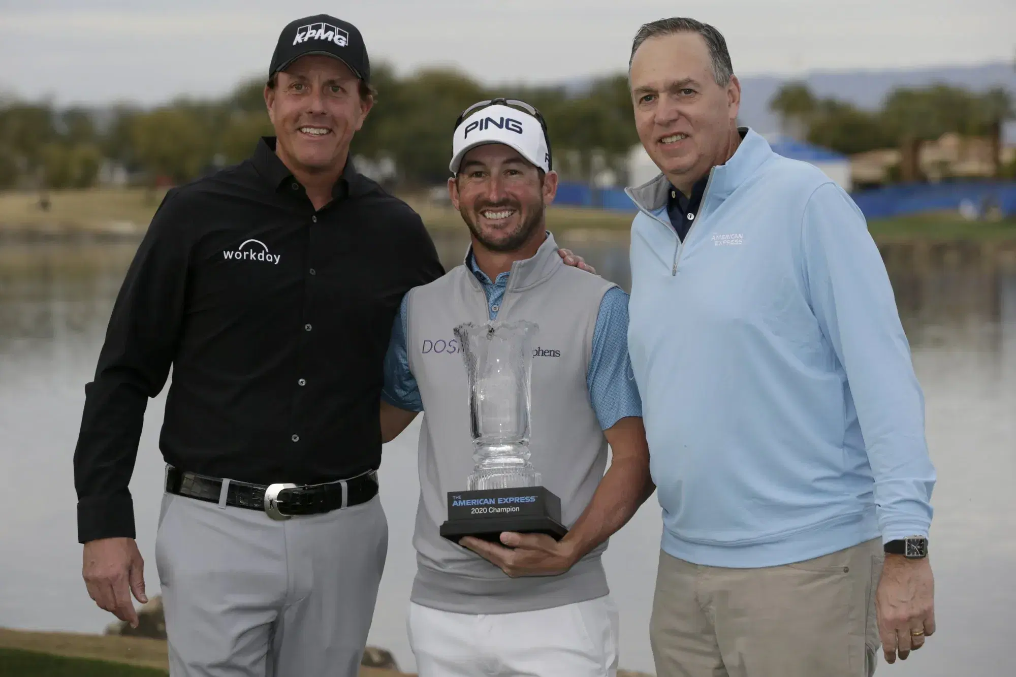 Andrew Landry, center, holds the trophy with Phil Mickelson, left, and CEO of American Express Steve Squeri after winning The American Express golf tournament on the Stadium Course at PGA West in La Quinta, Calif., Sunday, Jan. 19, 2020. (AP Photo/Alex Gallardo)