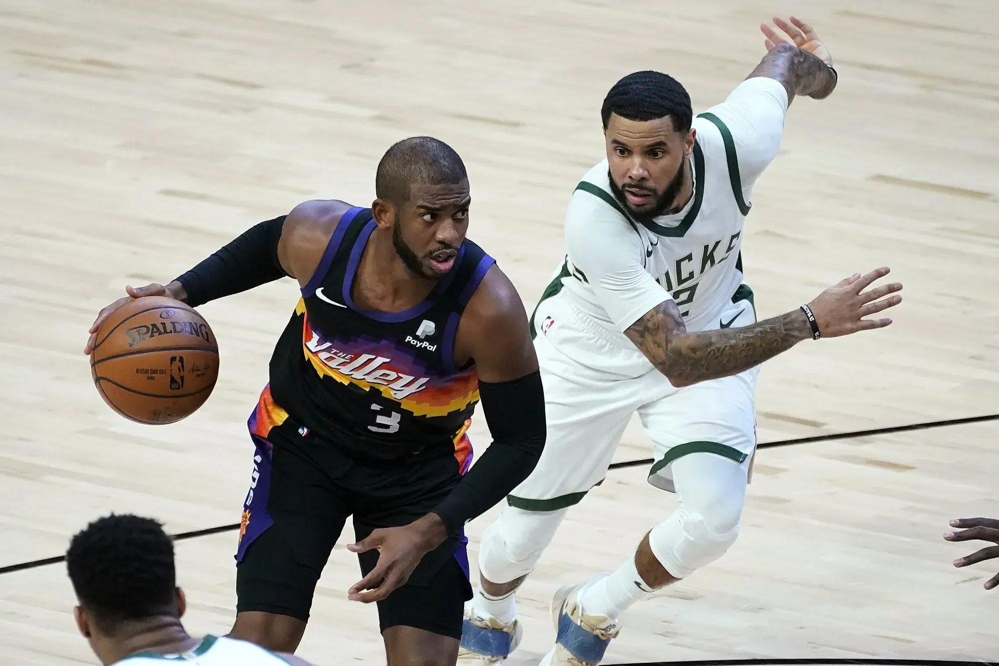 Phoenix Suns guard Chris Paul (3) drives as Milwaukee Bucks guard D.J. Augustin defends during the first half of an NBA basketball game Wednesday, Feb. 10, 2021, in Phoenix. (AP Photo/Matt York)