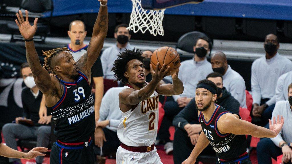 Feb 27, 2021; Philadelphia, Pennsylvania, USA; Cleveland Cavaliers guard Collin Sexton (2) drives for a score past Philadelphia 76ers center Dwight Howard (39) and guard Ben Simmons (25) during the second quarter at Wells Fargo Center. Mandatory Credit: Bill Streicher-USA TODAY Sports