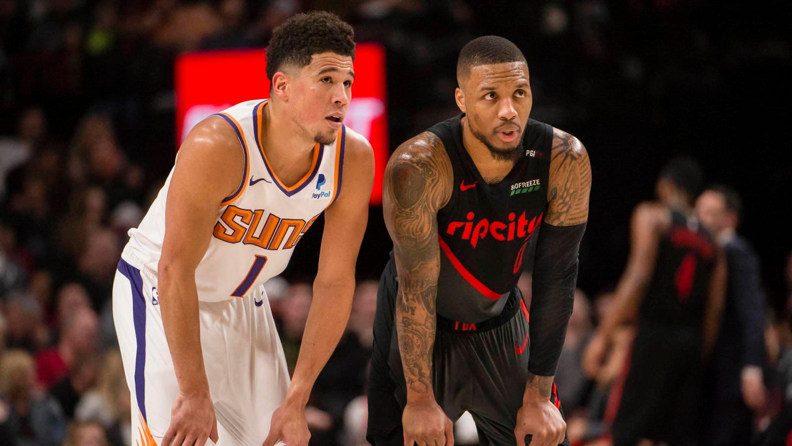 Mar 9, 2019; Portland, OR, USA; Phoenix Suns guard Devin Booker (1) and Portland Trail Blazers guard Damian Lillard (0) talk during a break in action during the second half at Moda Center. The Trail Blazers beat the Suns 127-120. Mandatory Credit: Troy Wayrynen-USA TODAY Sports