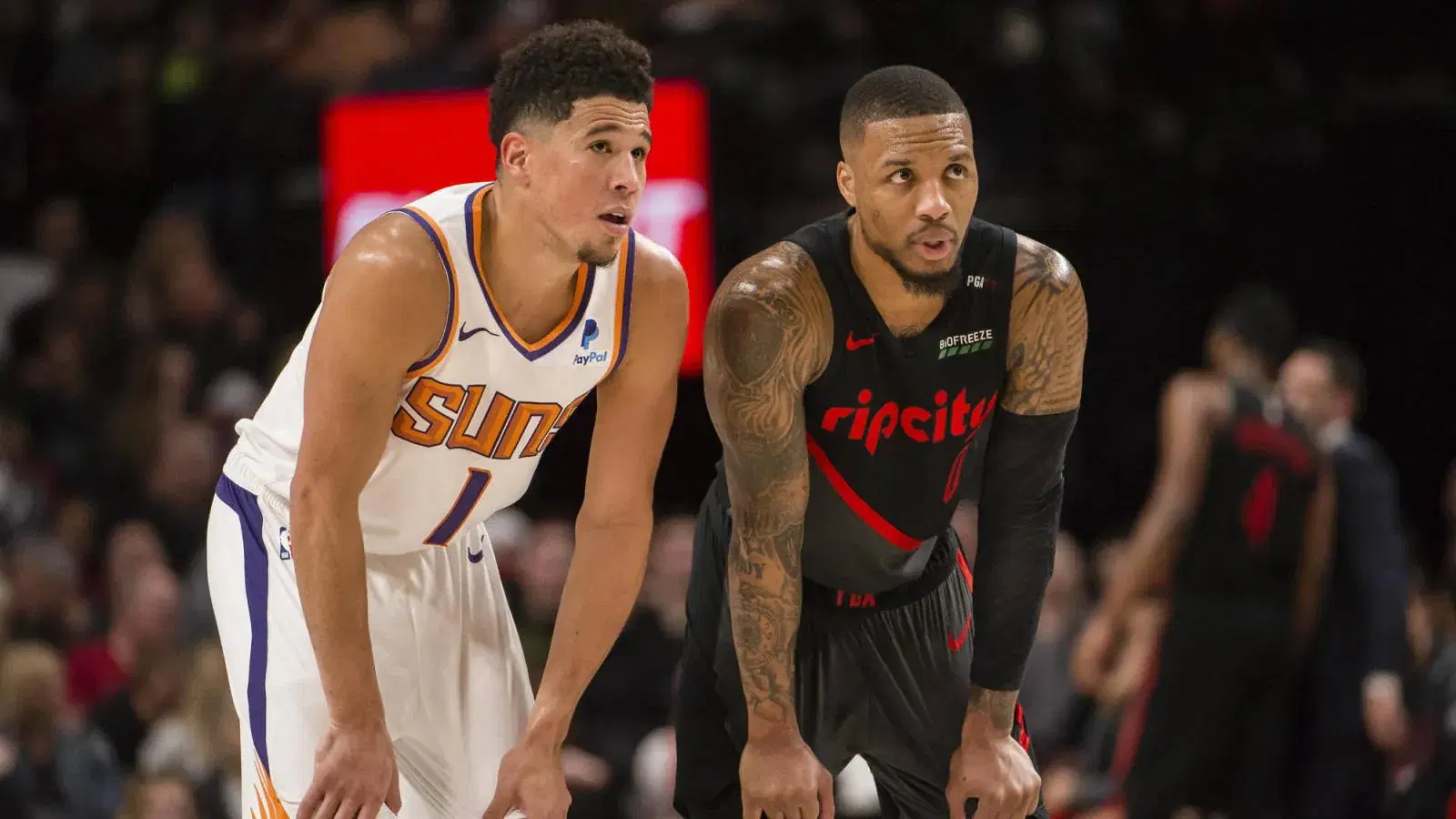 Mar 9, 2019; Portland, OR, USA; Phoenix Suns guard Devin Booker (1) and Portland Trail Blazers guard Damian Lillard (0) talk during a break in action during the second half at Moda Center. The Trail Blazers beat the Suns 127-120. Mandatory Credit: Troy Wayrynen-USA TODAY Sports
