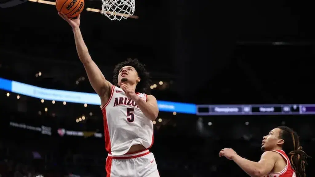 Arizona freshman sensation Brayden Burries (left, going for a layup) - #9 Utah State vs. #1 Arizona 2026 Men's March Madness West Region Second Round Prediction & Expert Picks cover